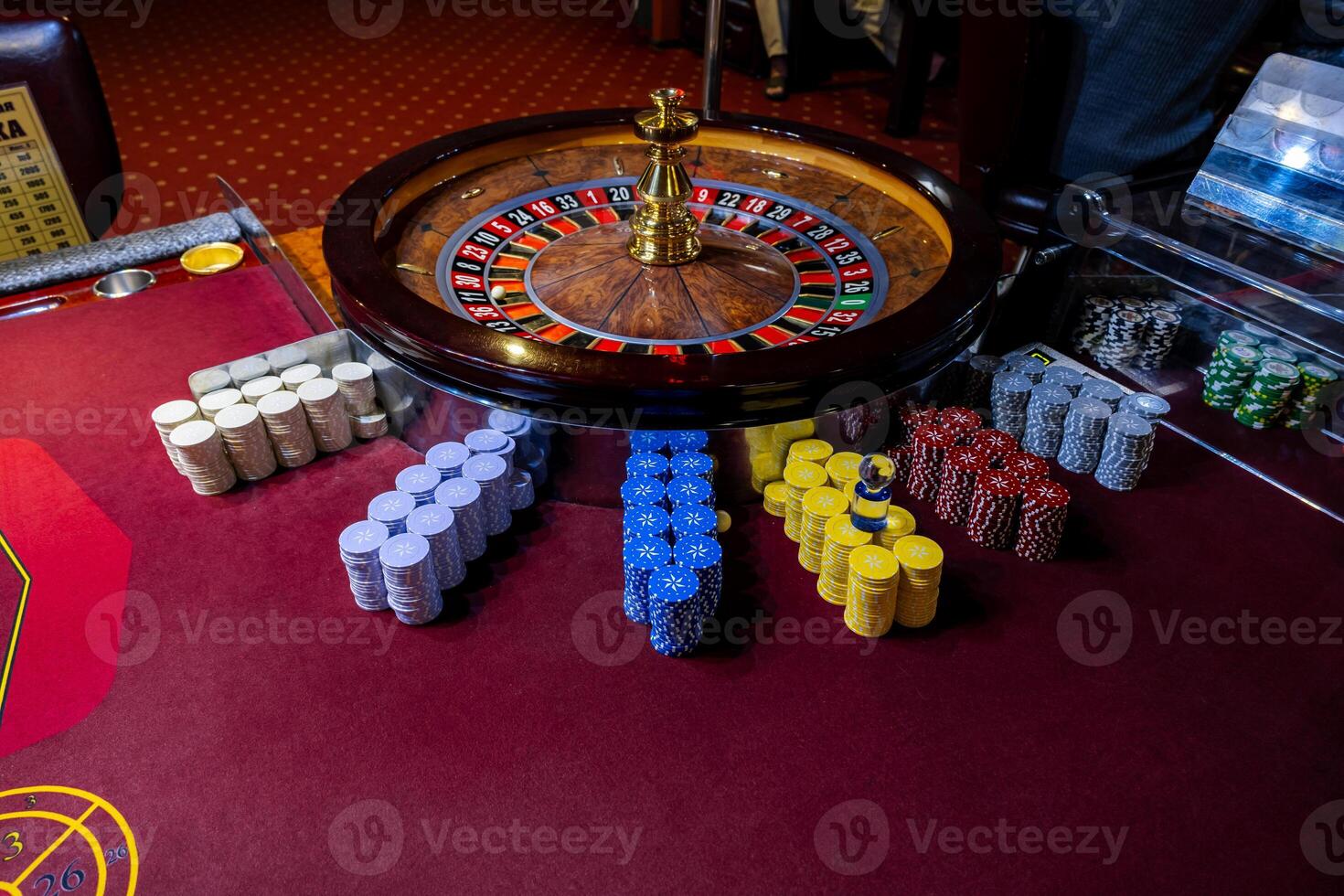 Roulette table in casino. Casino American Roulette gambling table with a wheel and playing chips on the layout. photo
