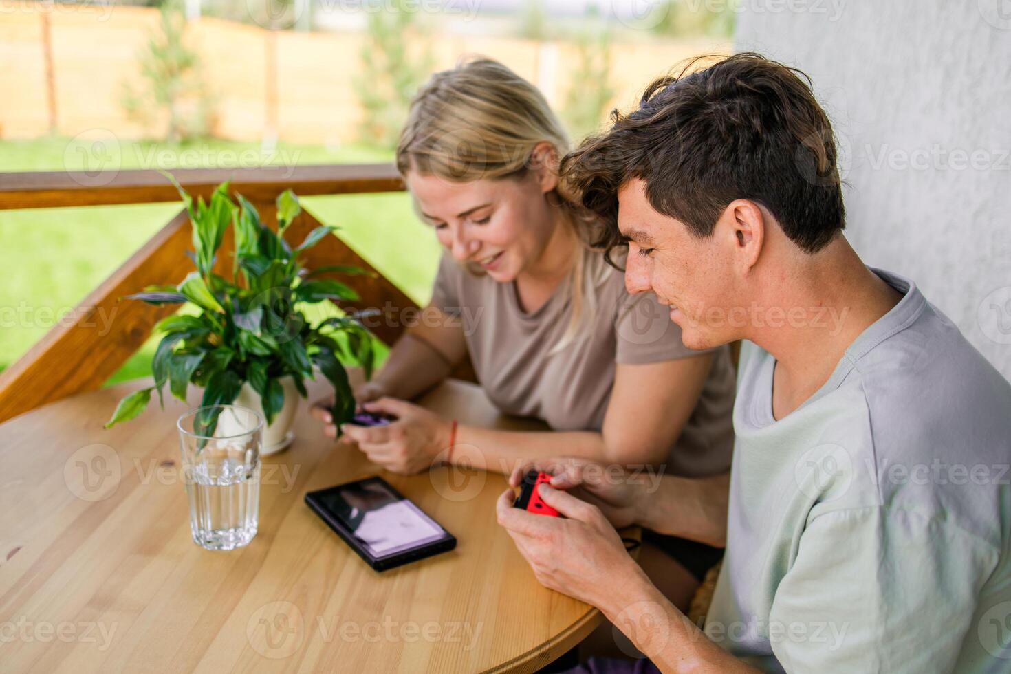 Joyful man and woman playing games on terrace. Technology and game console concept photo