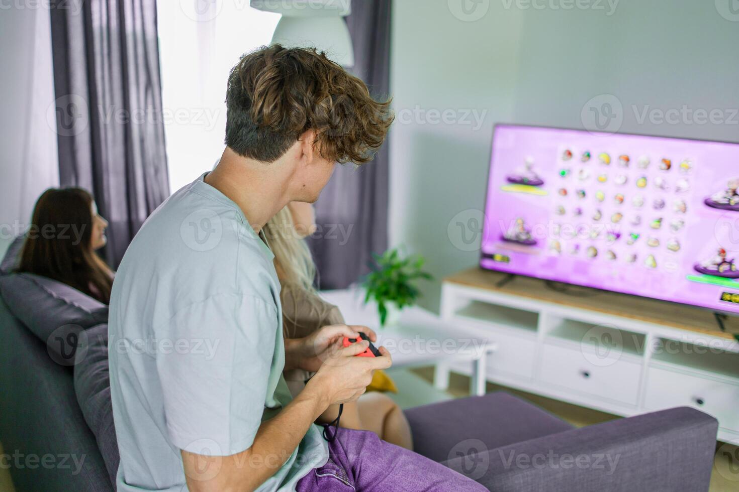 Excited gamer sitting and playing games on a console. Wireless controller and online game technologies concept photo