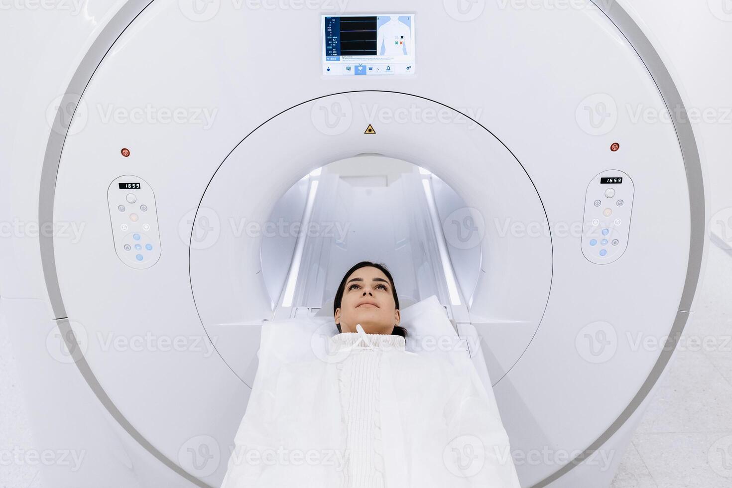 Female finished magnetic resonance imaging, Patient is moving out of MRI scanner capsule. Woman patient lies on an MRI scanner bed. Modern equipped cabinet in private clinic. Free copy space, ads photo