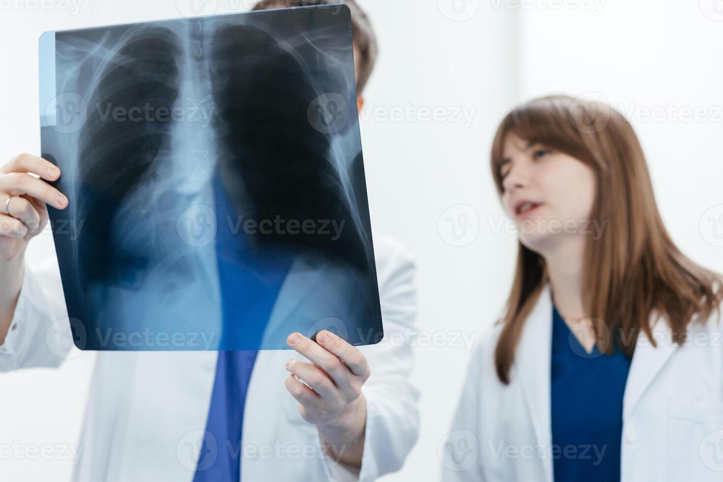 Two doctors in an MRI or CT room reviewing images and discussing the results. The concept of teamwork and precise analysis for diagnosing conditions of organs and the bone system. photo