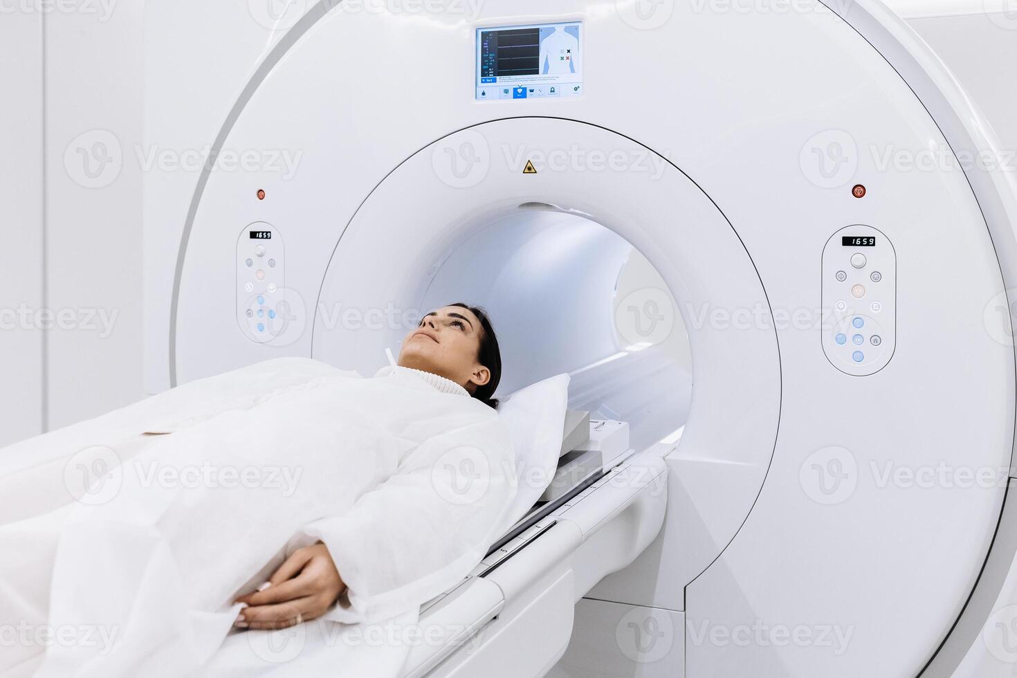 Female finished magnetic resonance imaging, Patient is moving out of MRI scanner capsule. Woman patient lies on an MRI scanner bed. Modern equipped cabinet in private clinic. Banner, free copy space photo