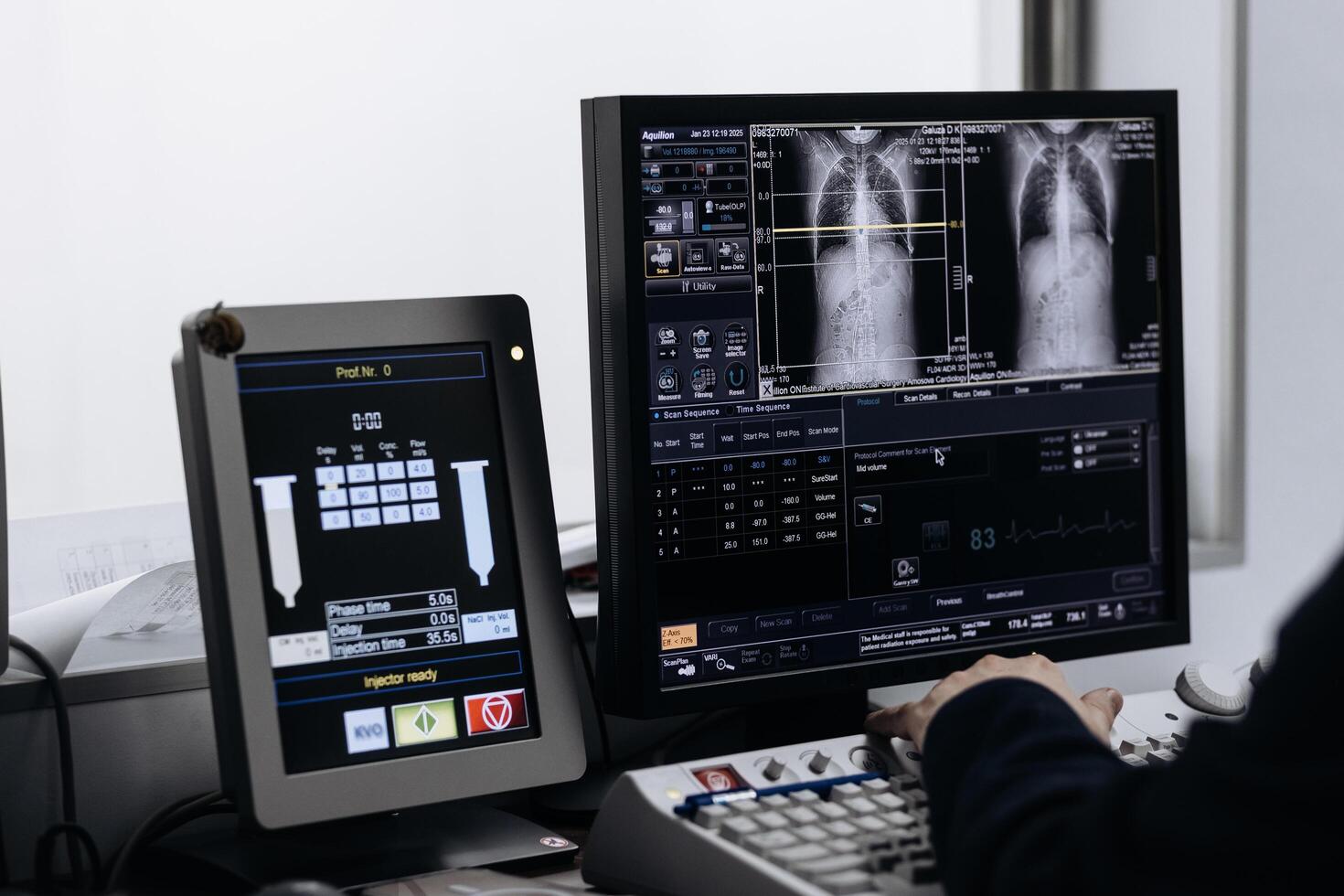 In Control Room Doctor and Radiologist Discuss Diagnosis while Watching Procedure and Monitors Showing Lungs Scans Results, In the Background Patient Undergoes MRI or CT Scan Procedure photo