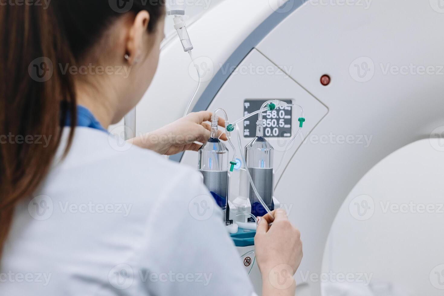 Back view of female doctor assists a patient undergoing an MRI scan, showcasing professionalism and modern medical technology in a healthcare setting. photo