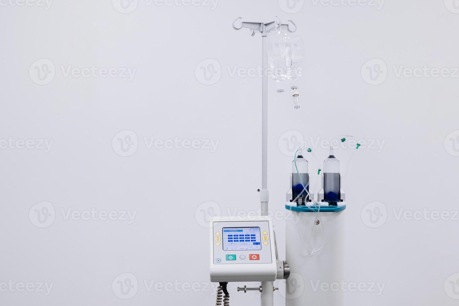 A drip with saline solution in the operating room. Syringe pump with medical equipment background. Intravenous fluid infusion for patient with blood loss during surgery. Isolated on white. Copy space photo