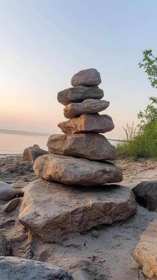 A stack of rocks on the beach at sunset photo