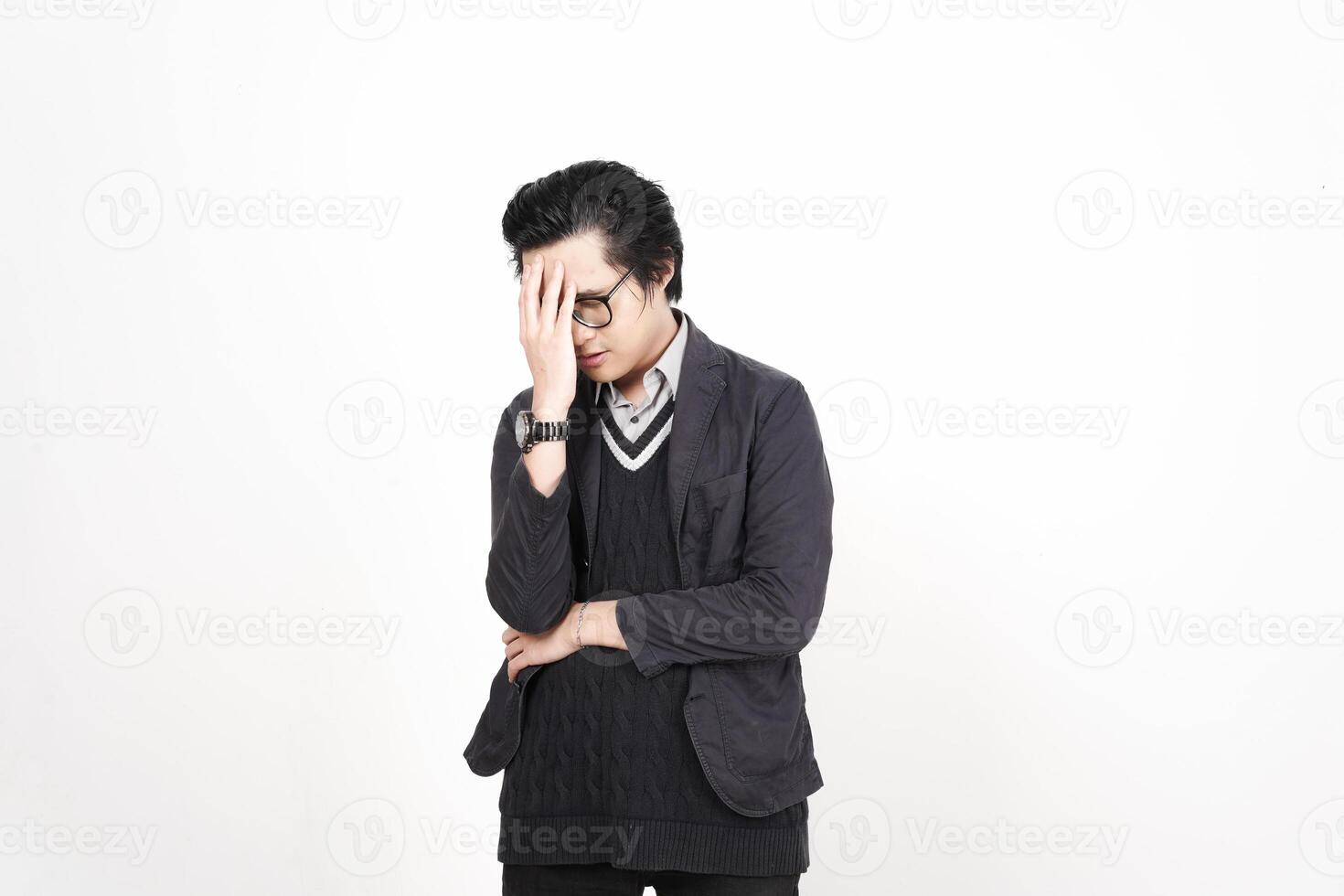A man with glasses and a sweater is standing with his hands on his head photo