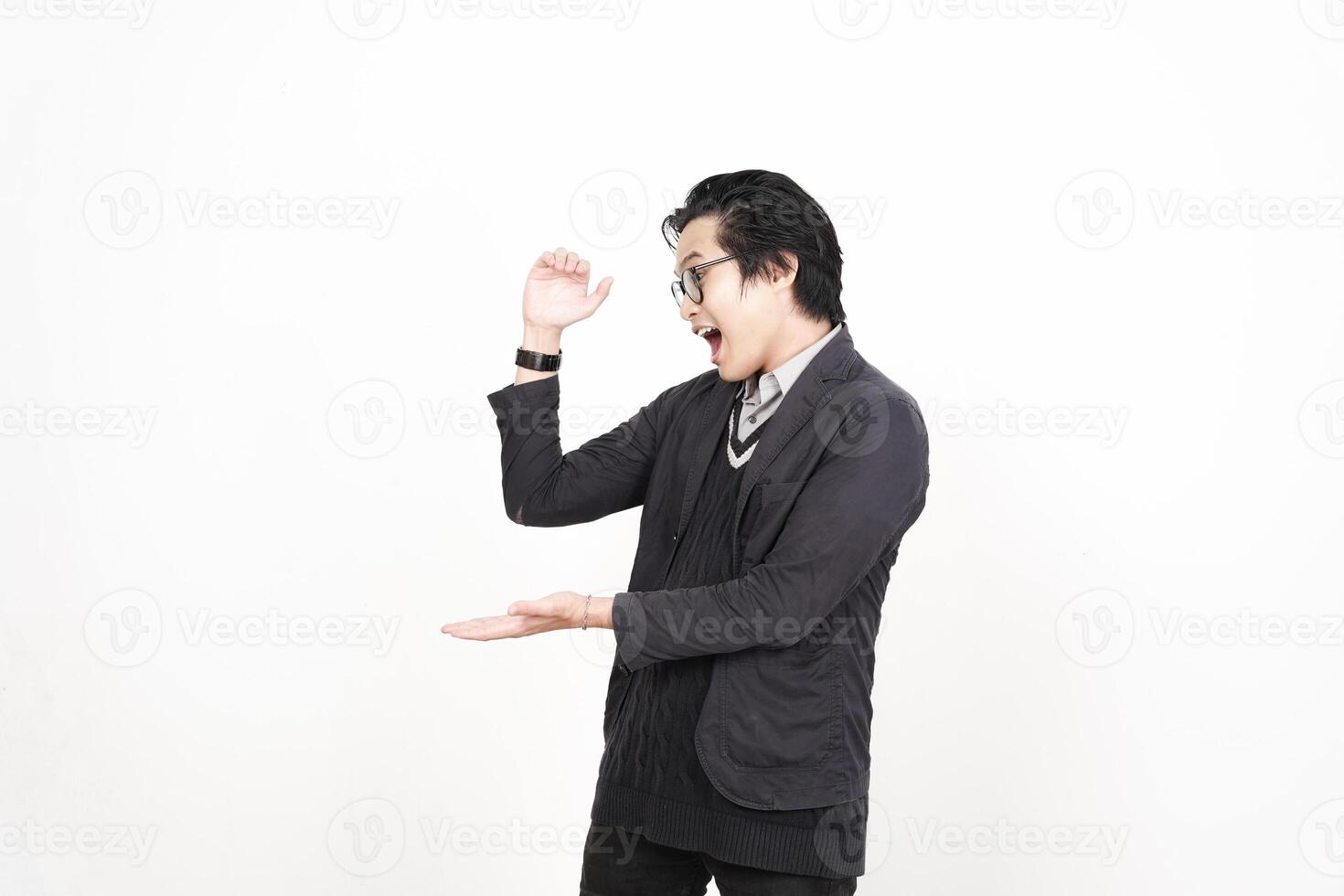 A man in a black jacket and glasses is standing with his hands out photo
