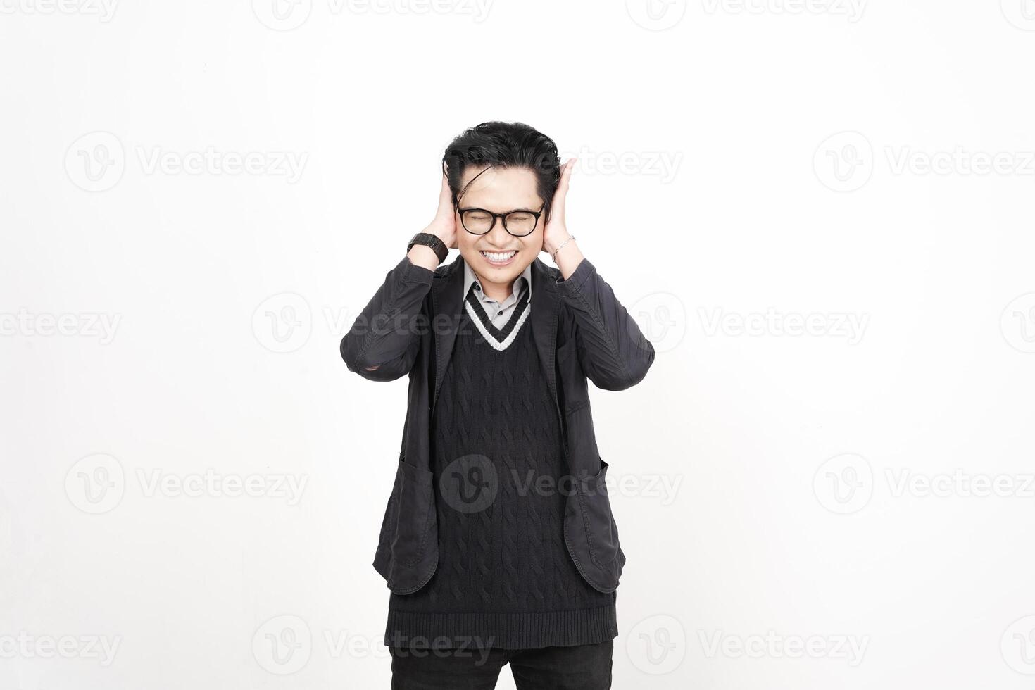 A man in glasses and a sweater is holding his hands to his ears photo