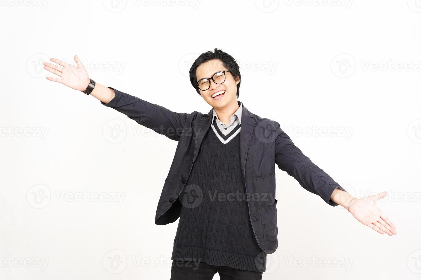 A man in glasses and a sweater is standing with his arms outstretched photo