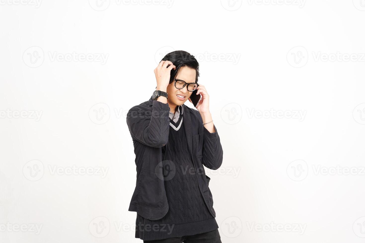 A man in glasses and a sweater talking on a cell phone photo