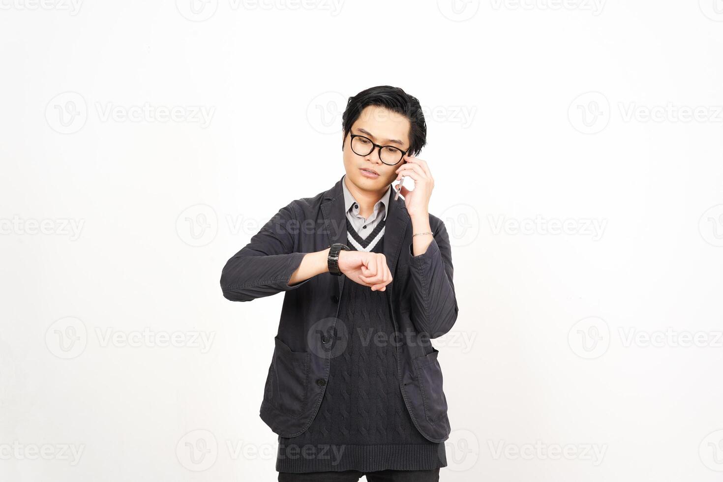 A man in glasses and a sweater is holding his wrist watch photo