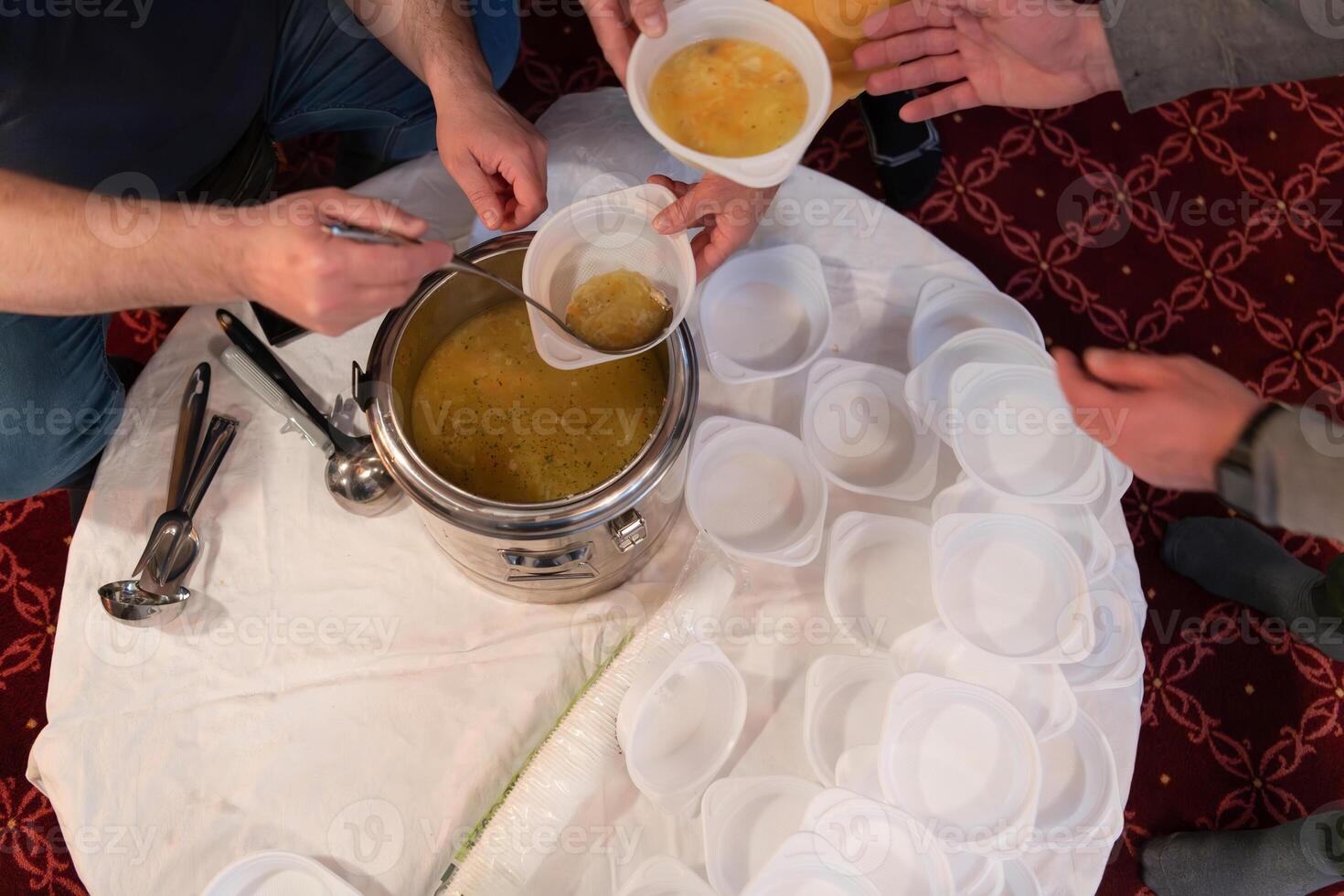 Top view of people serving food at a Mosque a communal meal during Ramadan before breaking the fast on Iftar dinner. Warm festive atmosphere celebrating Ramadan Karim and Eid, the Islamic holy month photo