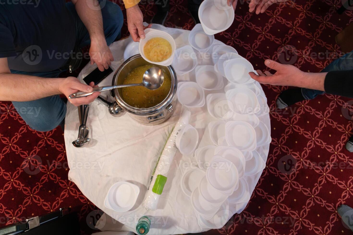 Top view of people serving food at a Mosque a communal meal during Ramadan before breaking the fast on Iftar dinner. Warm festive atmosphere celebrating Ramadan Karim and Eid, the Islamic holy month photo