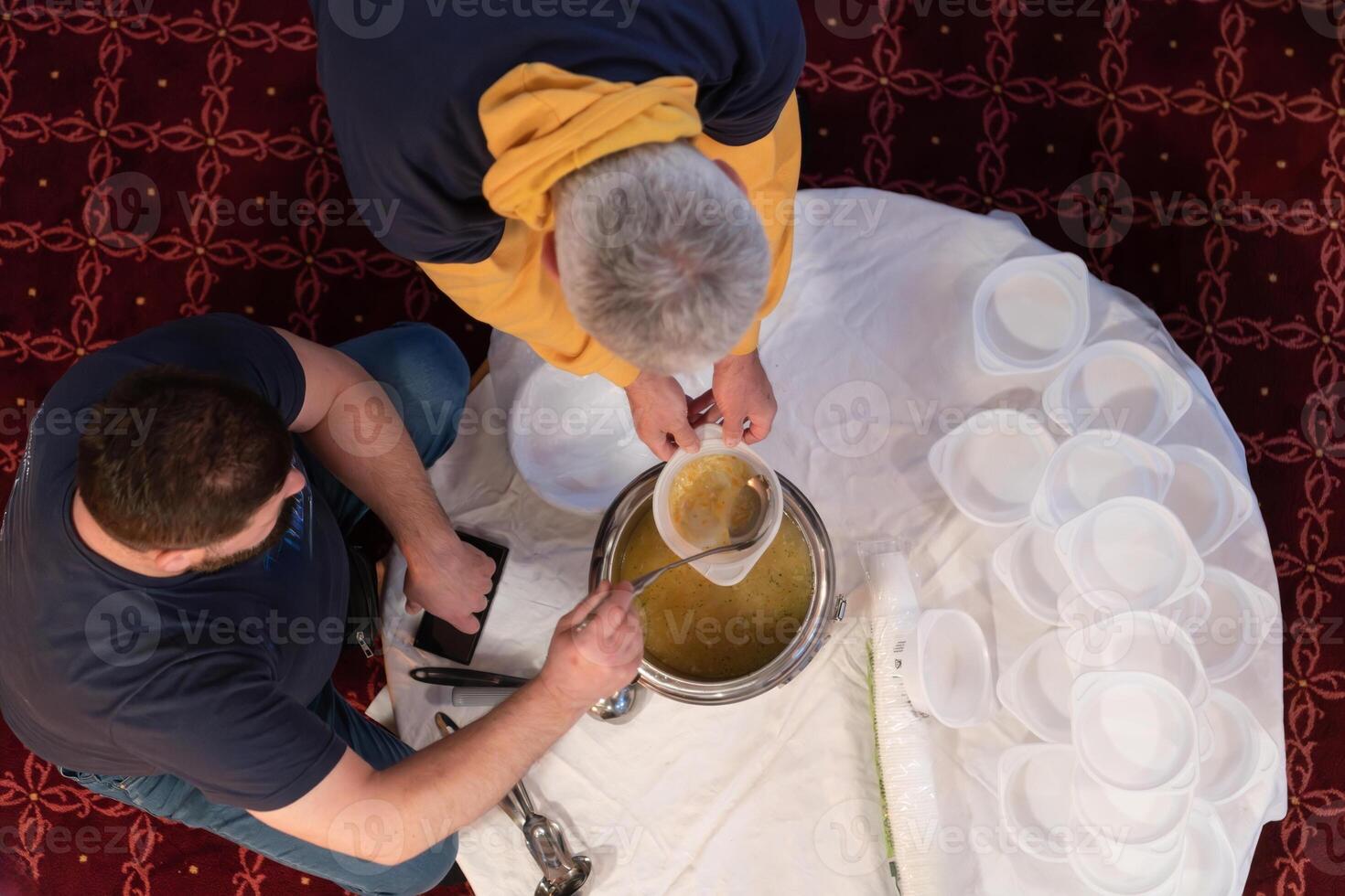 Top view of people serving food at a Mosque a communal meal during Ramadan before breaking the fast on Iftar dinner. Warm festive atmosphere celebrating Ramadan Karim and Eid, the Islamic holy month photo