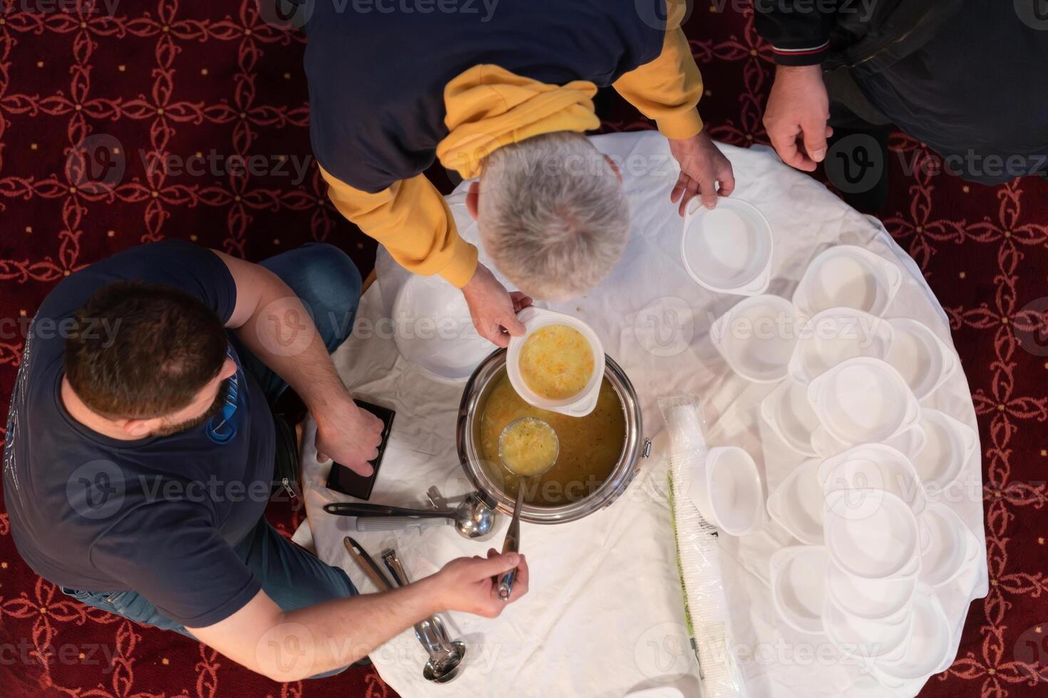 Top view of people serving food at a Mosque a communal meal during Ramadan before breaking the fast on Iftar dinner. Warm festive atmosphere celebrating Ramadan Karim and Eid, the Islamic holy month photo