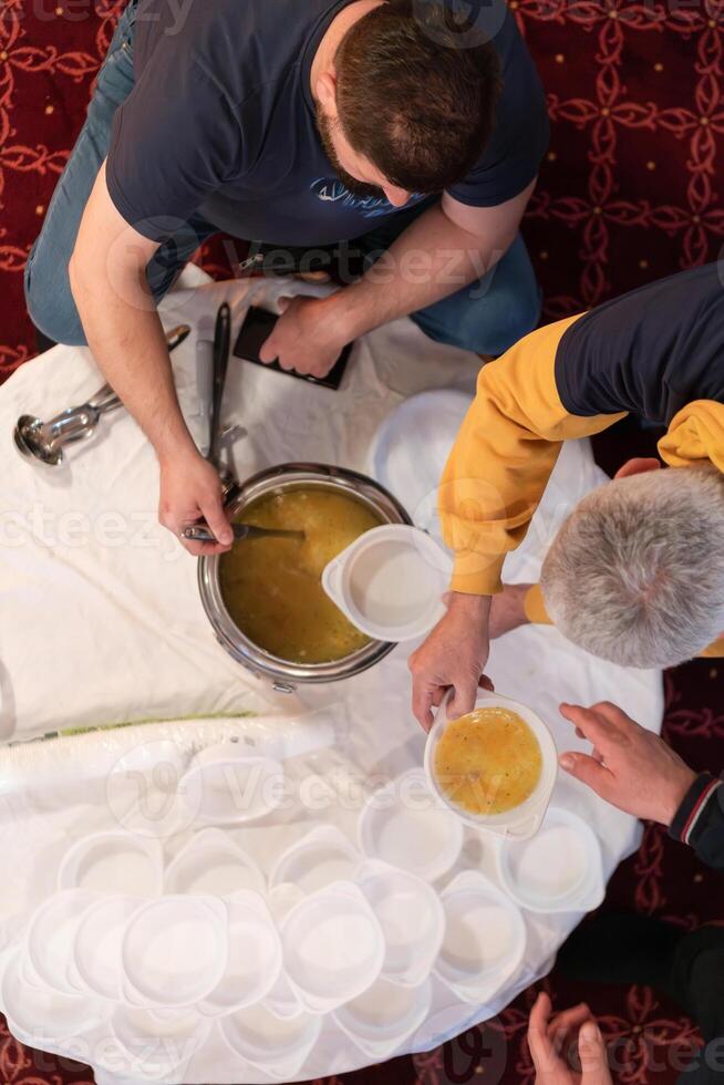 Top view of people serving food at a Mosque a communal meal during Ramadan before breaking the fast on Iftar dinner. Warm festive atmosphere celebrating Ramadan Karim and Eid, the Islamic holy month photo