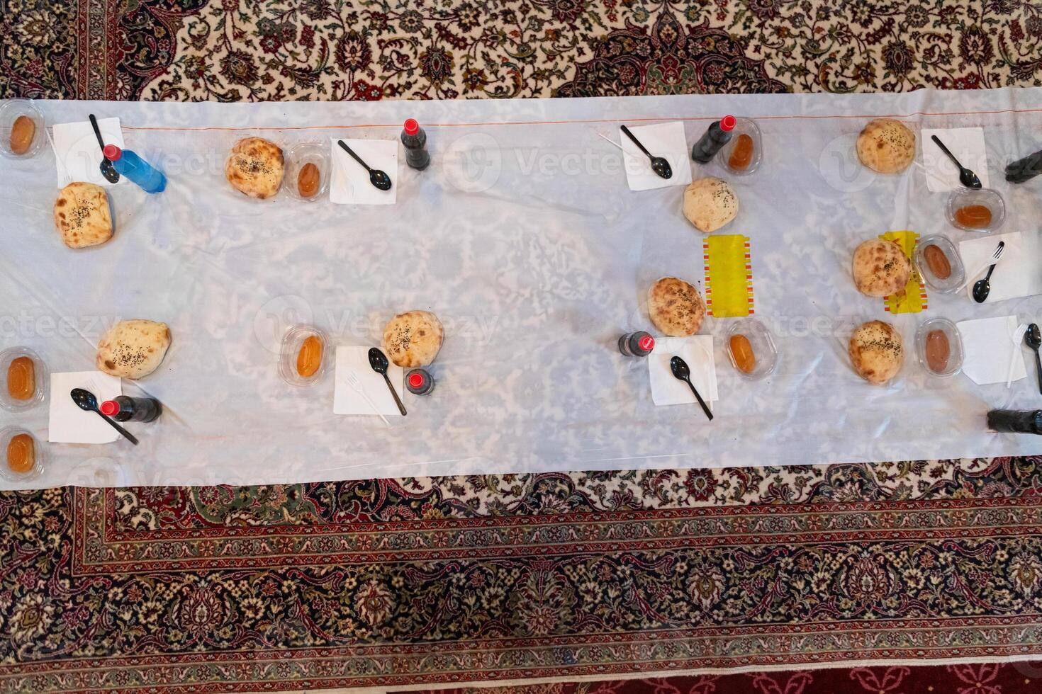 Top view of people serving food at a Mosque a communal meal during Ramadan before breaking the fast on Iftar dinner. Warm festive atmosphere celebrating Ramadan Karim and Eid, the Islamic holy month photo