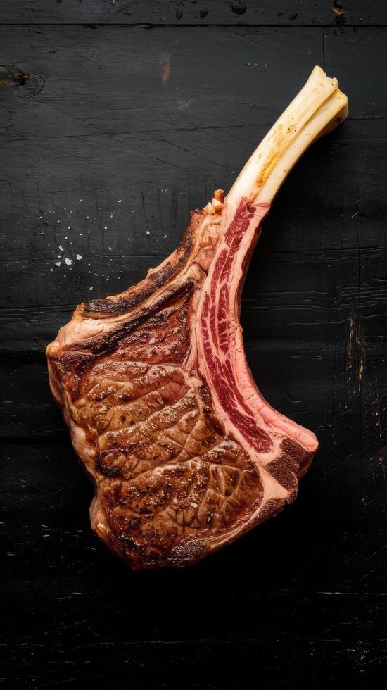 Steak on the bone tomahawk steak on a black wooden background top view free copy space photo