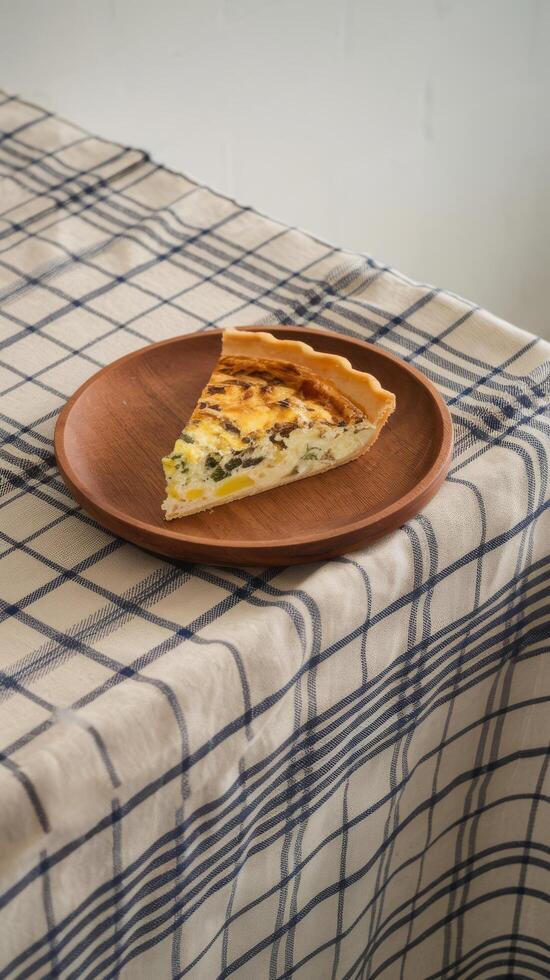 A slice of quiche on a plate on a table photo