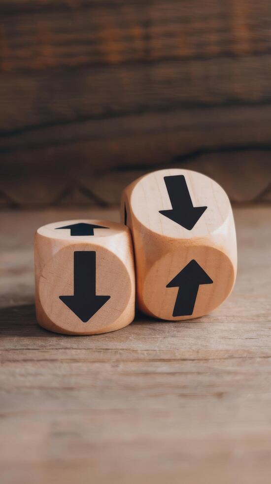 Two wooden dice with arrows pointing down on a wooden table photo