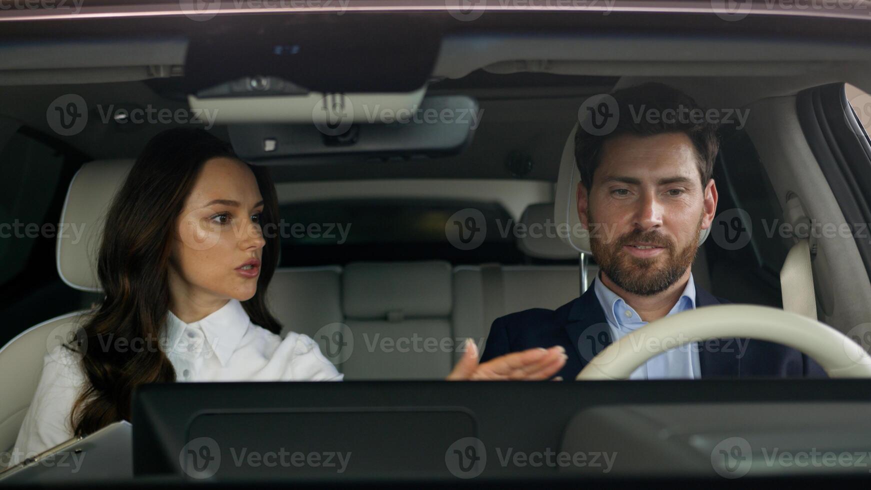 Woman female girl consultant trader talking consult client buyer sitting together in salon of new car automobile choosing vehicle in showroom man businessman guy business male buying auto test drive photo