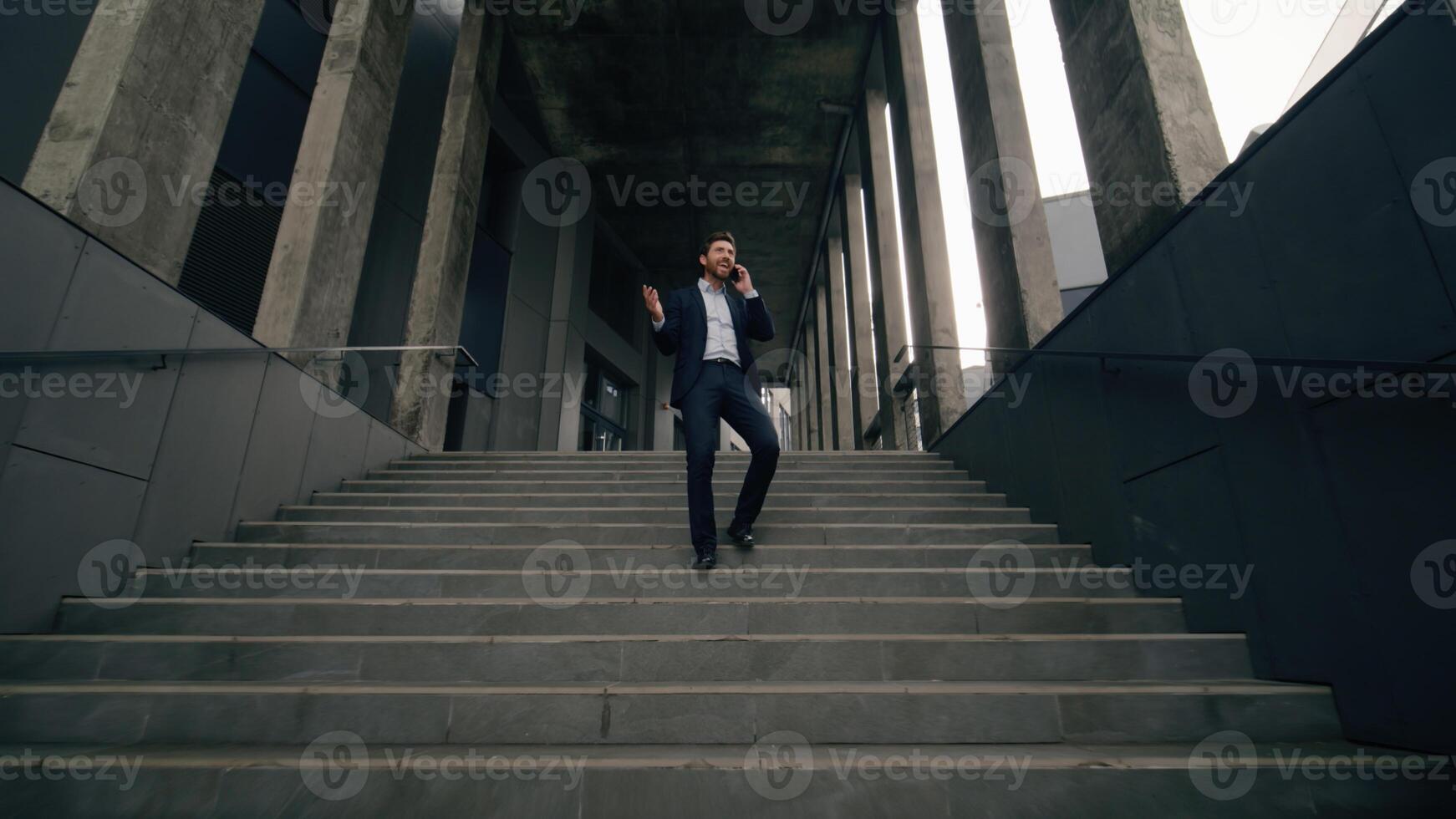 Full-length view businessman talking business call talk mobile phone outside walking stairs down stairway leave office building negotiate distant man male guy employer answer speaking smartphone going photo