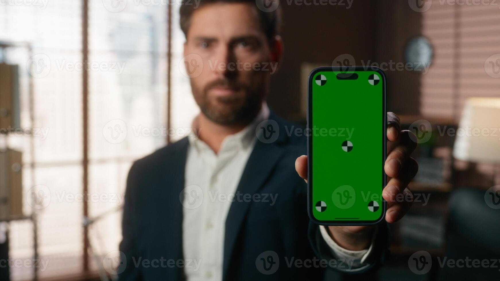 Portrait in office serious business specialist middle-aged Caucasian man businessman worker male guy holding mobile phone with green screen template chroma key mock up showing smartphone display app photo