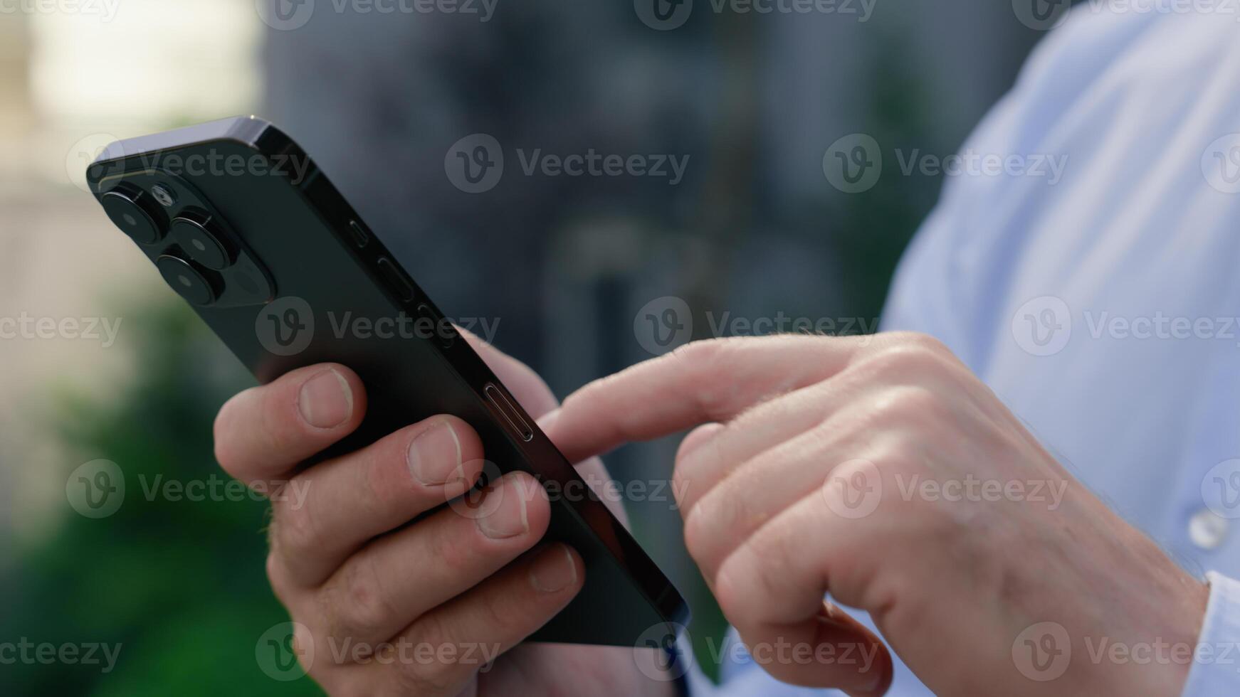 Close up male hands holding mobile phone in city formal unrecognizable businessman business chat service app company online unknown man guy user scrolling screen display touch using smartphone web net photo