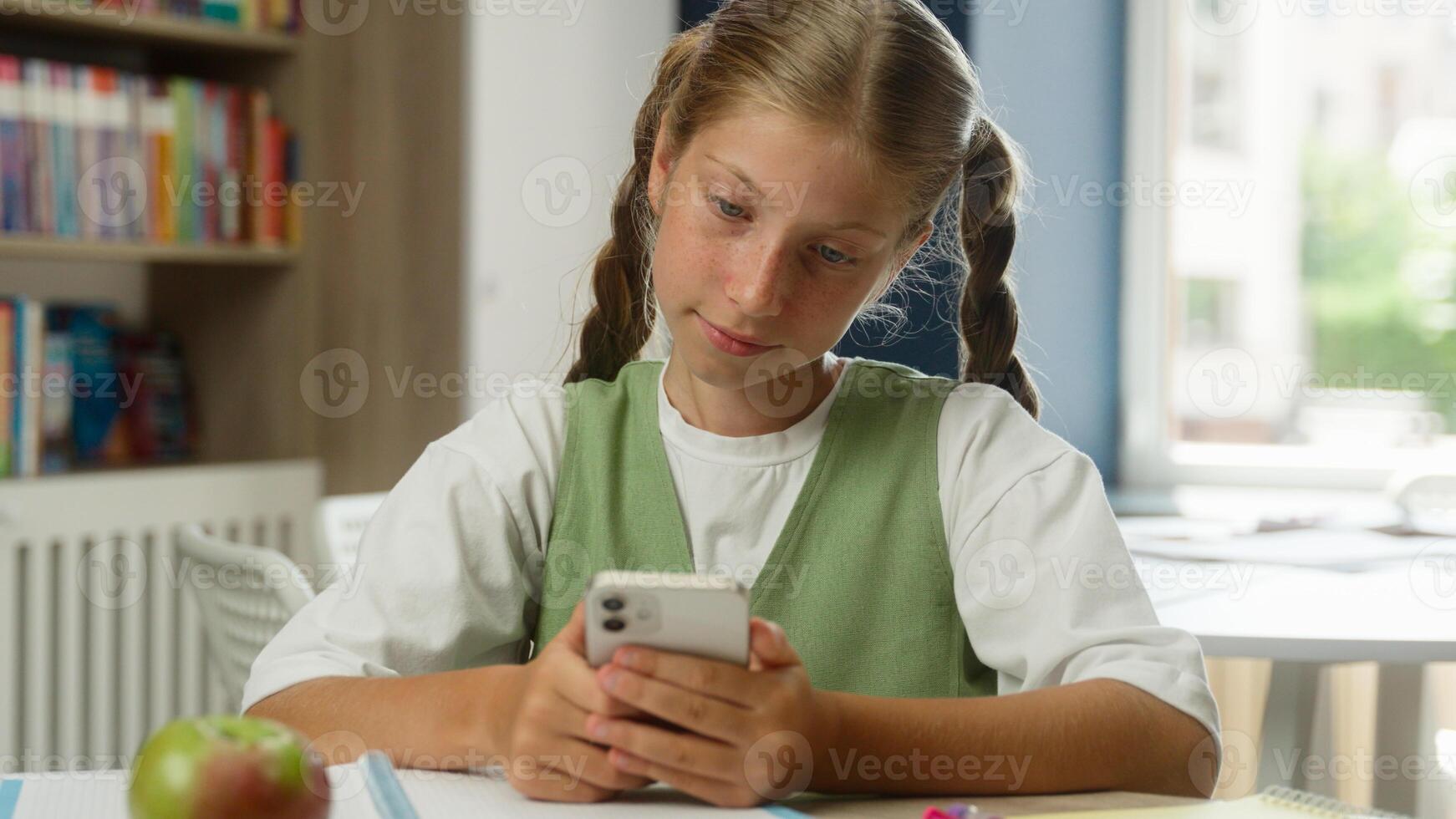 School student girl child teenager kid pupil schoolgirl using mobile phone app gadget addict smartphone chatting browsing online social media blogger influencer smiling searching internet in classroom photo