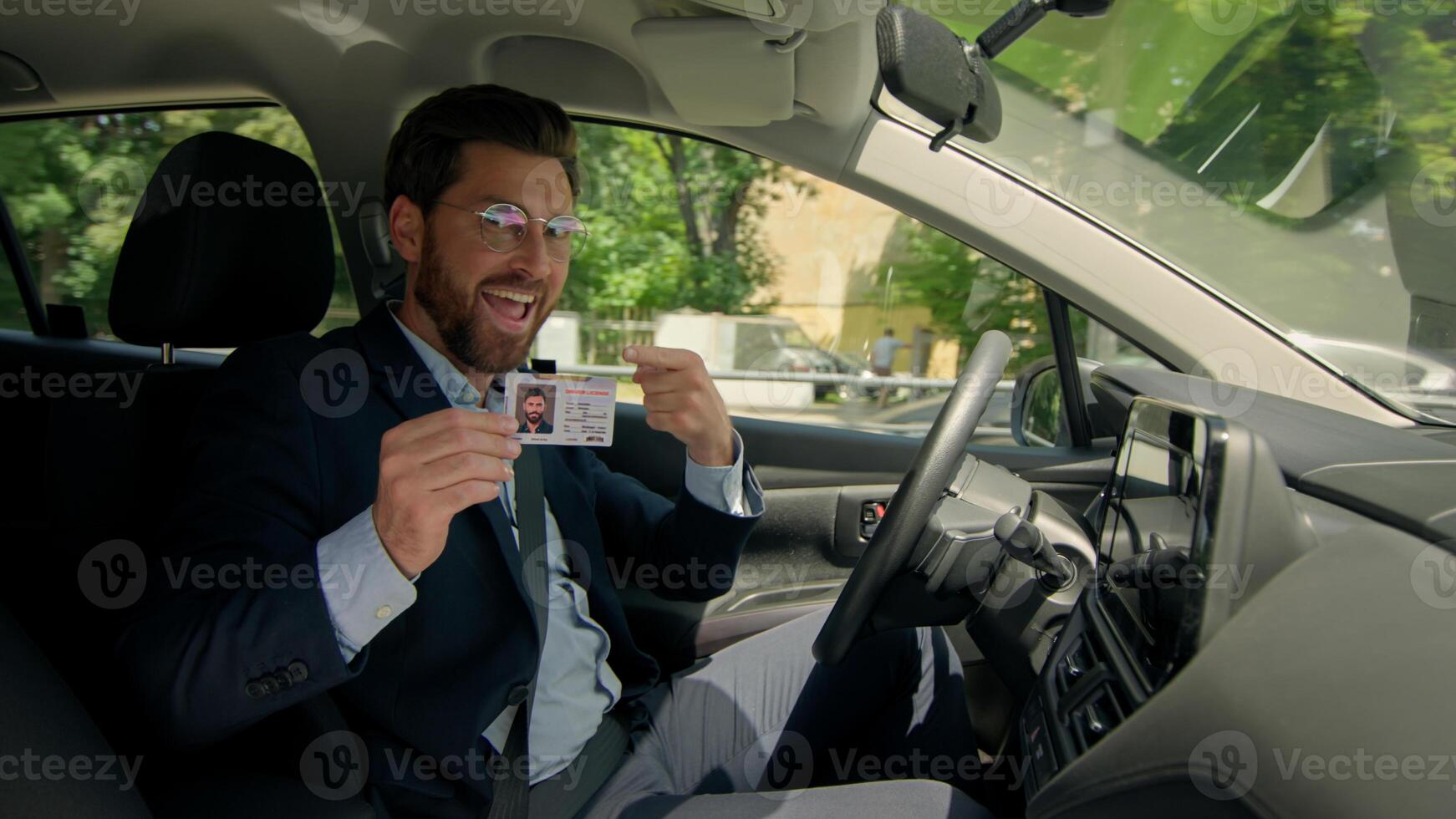 Happy smile man Caucasian male guy businessman in own car drive city road demonstrate driver license at camera document plastic card automobile insurance rent auto buy transport pass exam driving test photo