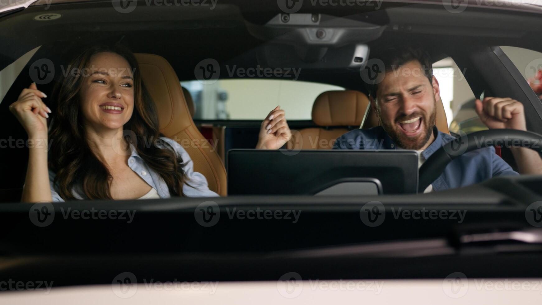 Happy dancing funny moving to music radio technology audio stereo system inside car Caucasian couple in auto dance woman girl female girlfriend with man guy male boyfriend travel joy automobile auto photo
