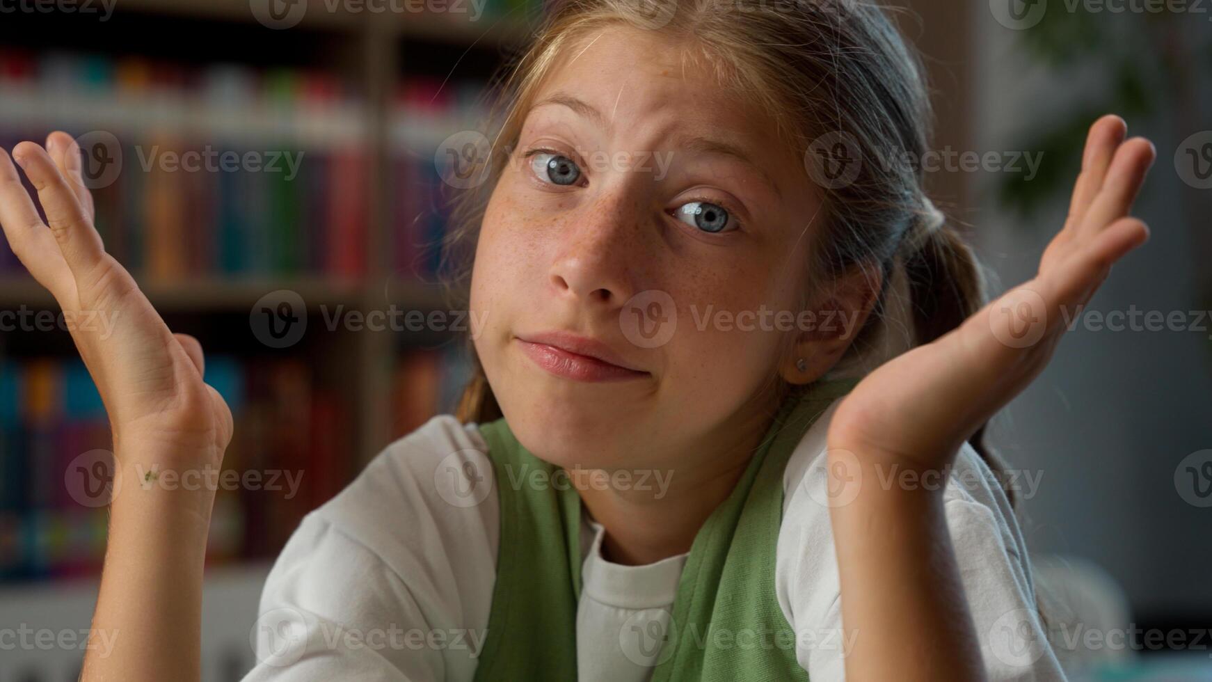 Close up sad upset confused Caucasian little girl puzzled child school kid student pupil schoolgirl looking camera doubt shrugging shoulders don't know answer no clue education learning in classroom photo
