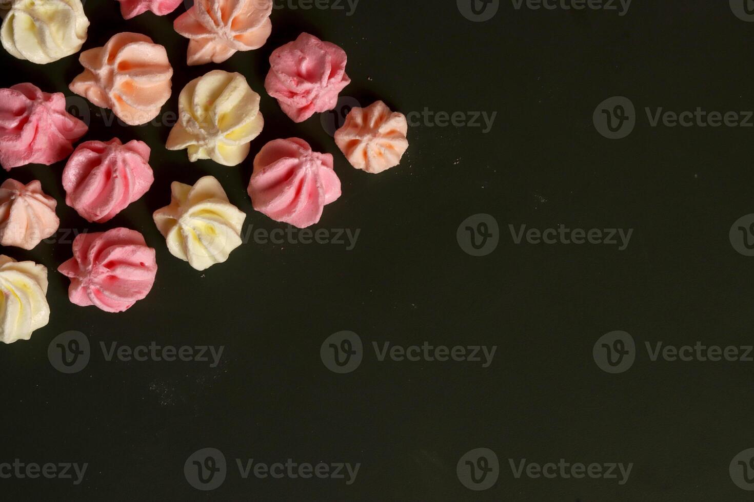 a pile of colorful meringue cookies on a black background photo