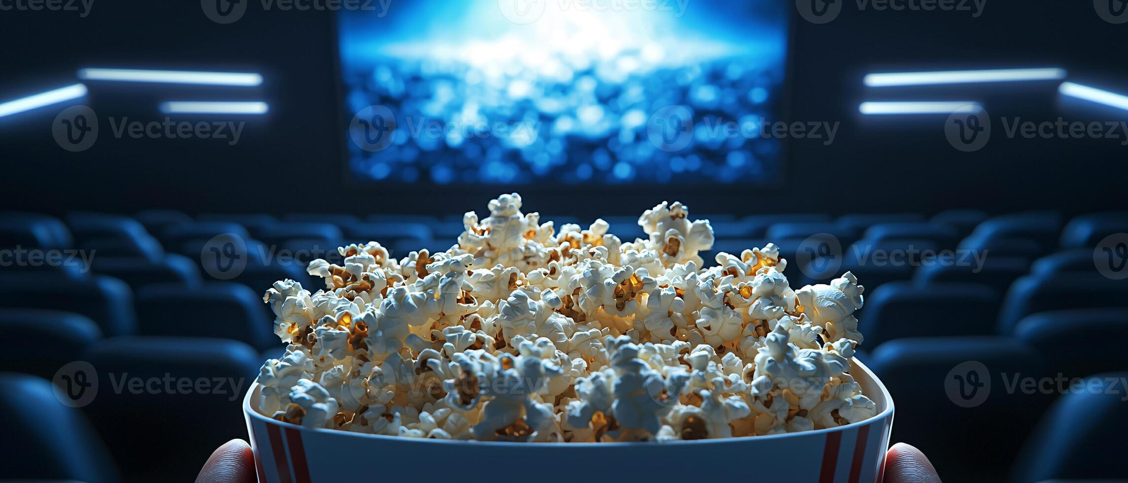 Bowl of Popcorn in a Movie Theater with Empty Seats and Screen Light photo
