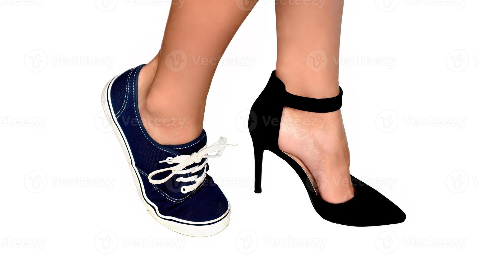 Two different types of shoes high heels and sneakers on womens feet. Isolated on white background.Concept of females choice of elegance and beauty vs comfort and simplicity. photo
