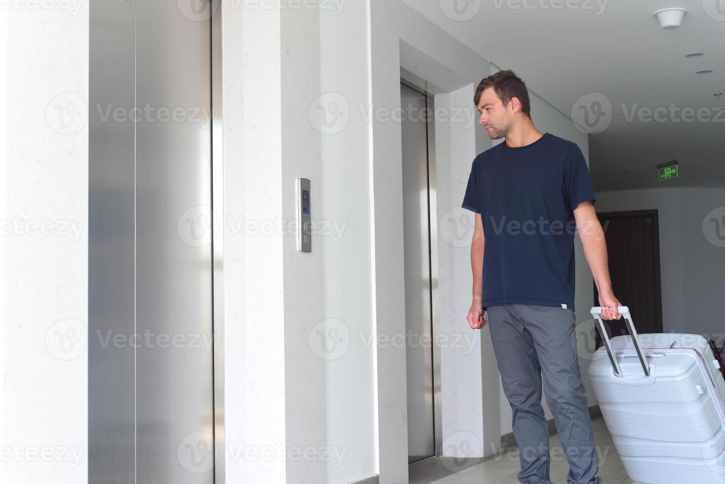 Young Russian man waiting for lift with a suitcase. emigration concept photo