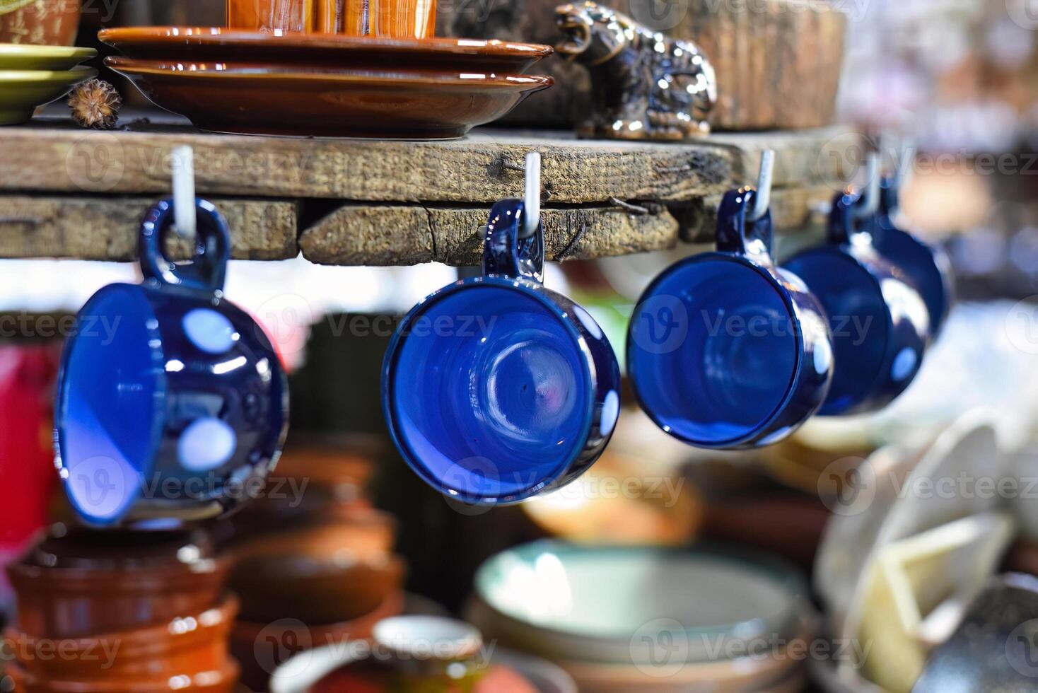 Many blue plain cups hanging in the kitchen photo