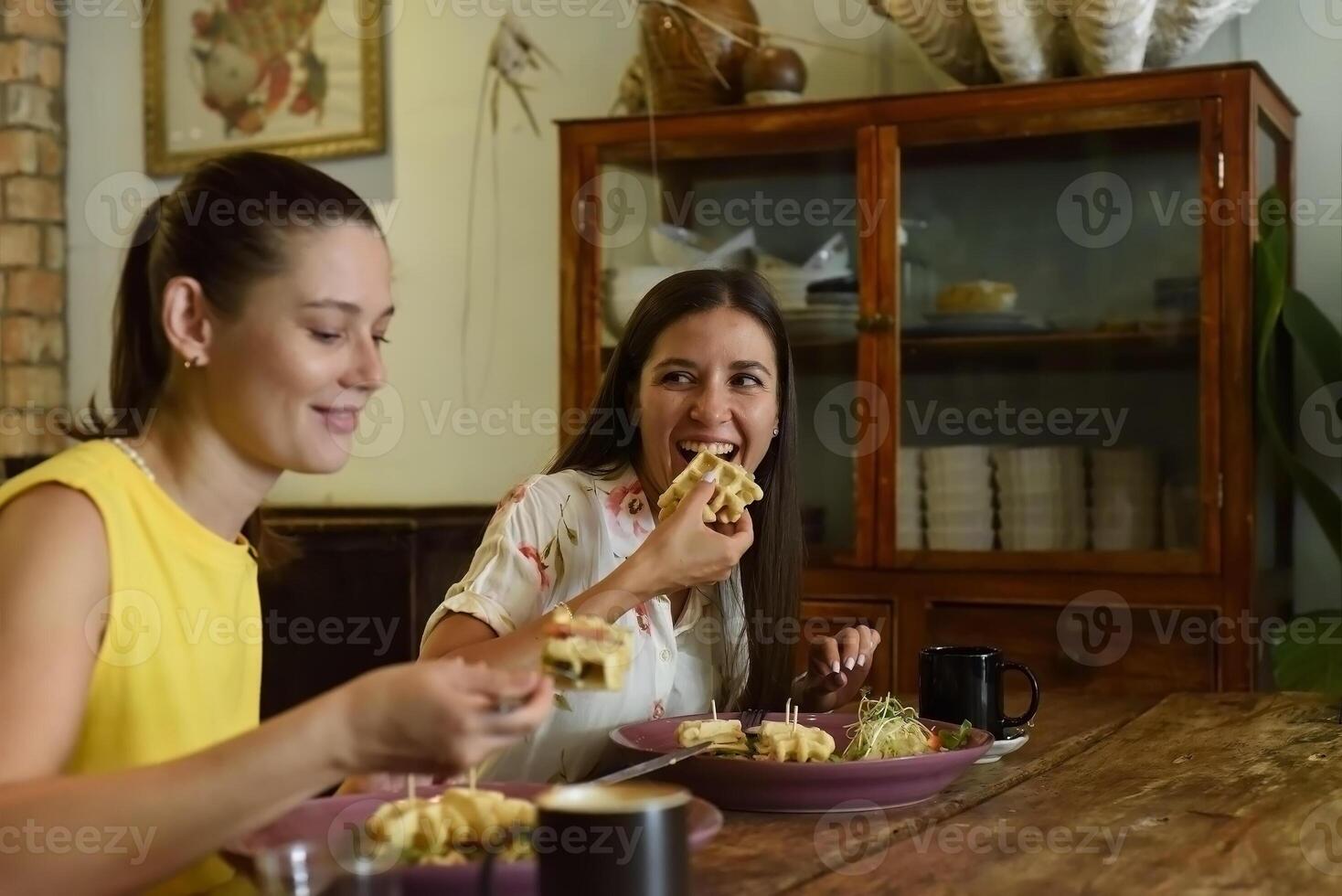 Two best friends talking and eat in a cafe photo