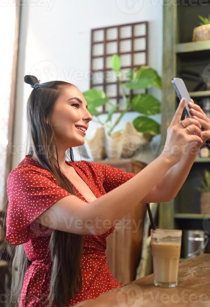 Young woman takes selfie in coffee shop photo