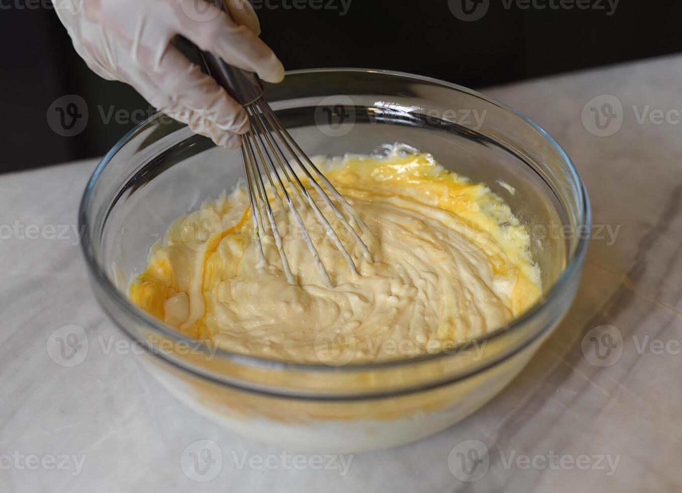 A hands in rubber gloves stirring photo