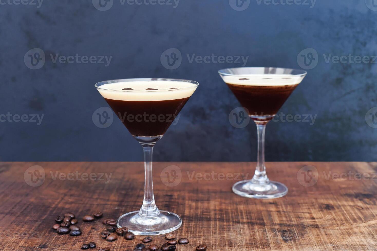 Glasses of espresso martini with coffee beans on the wooden table photo
