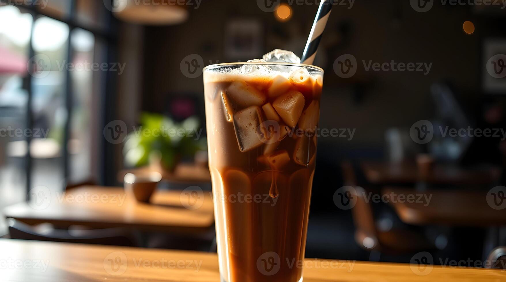 An iced coffee with a straw on top of a table photo