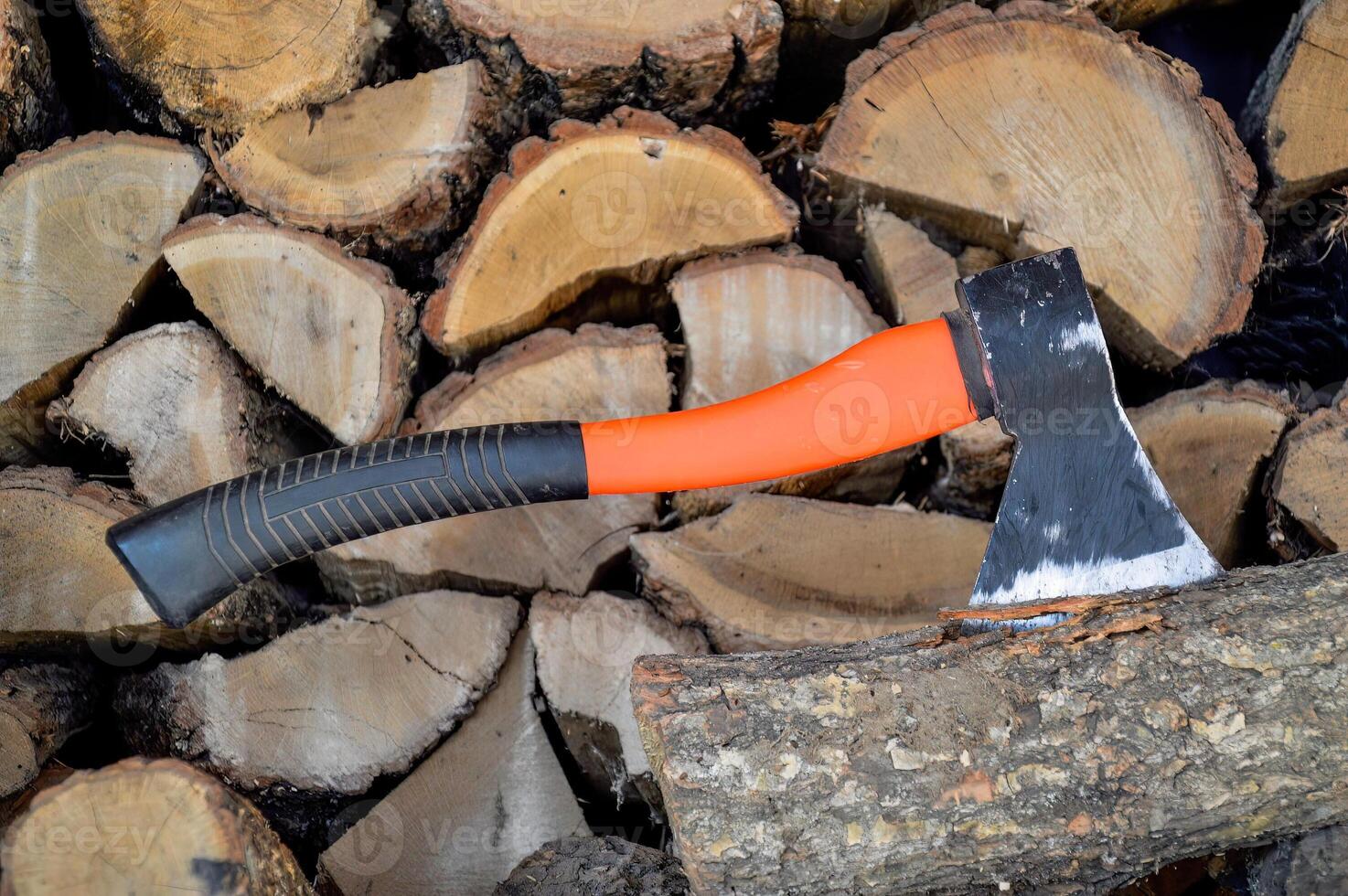 Ax stuck in a log against the background of lumber photo
