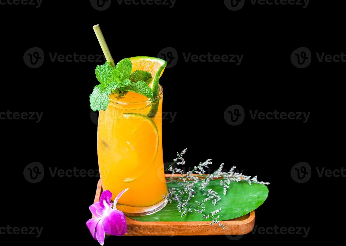 Orange juice with slice of orange with flower isolated on black background photo