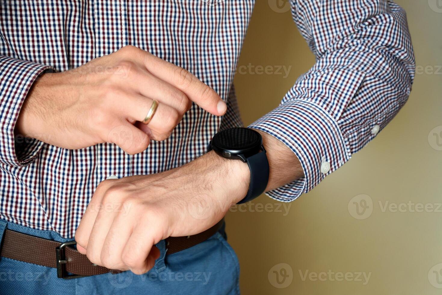 Male hands touching screen and using his smart watch app. Close-up hands photo