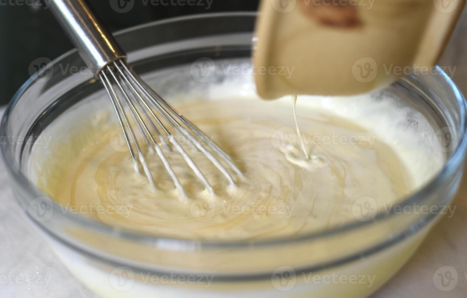 Egg beater in a bowl mixing dough photo