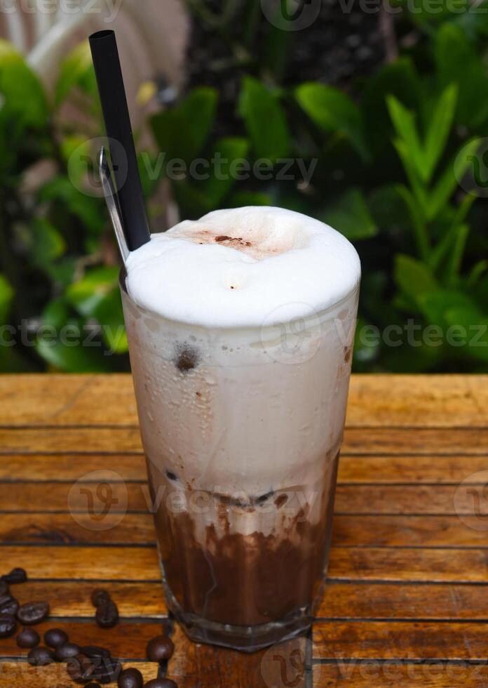 Coffee shake with ice cream and chocolate on wooden table with coffee beans photo