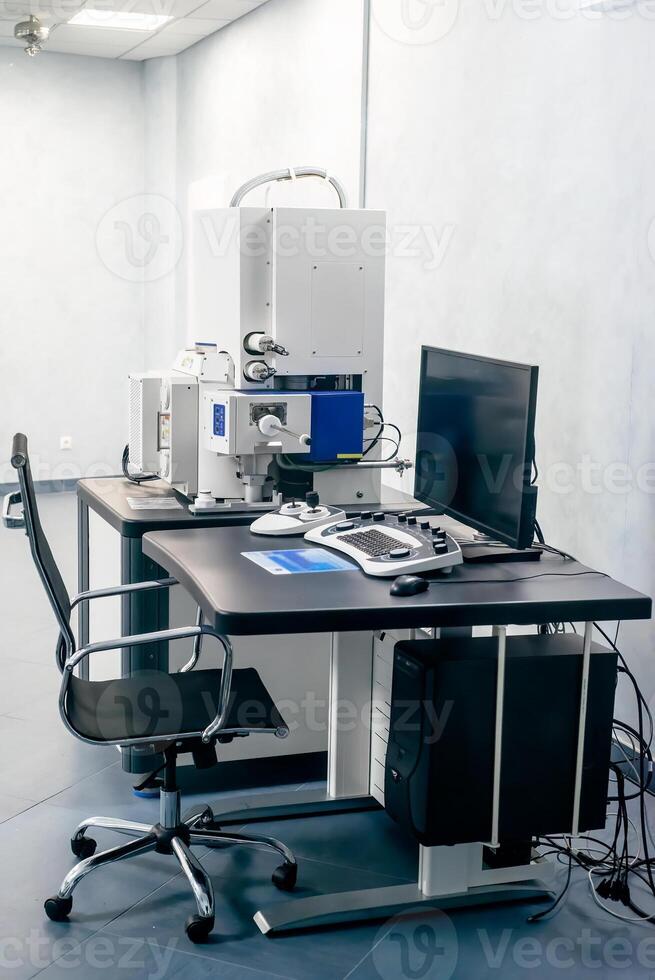 Work space of scientist with Electron microscope, table and computer photo
