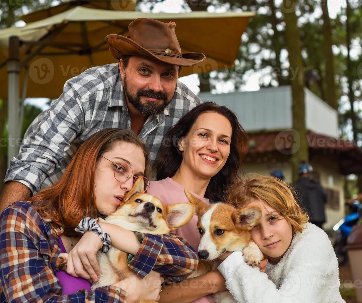 Family member father mother and 2 daughters with corgi dogs in the forest photo